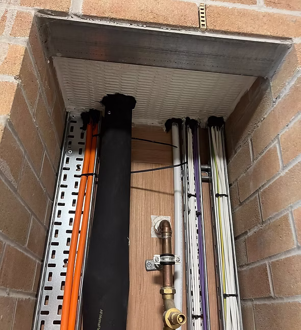 Firestopping installed around service penetrations through a fire-rated wall