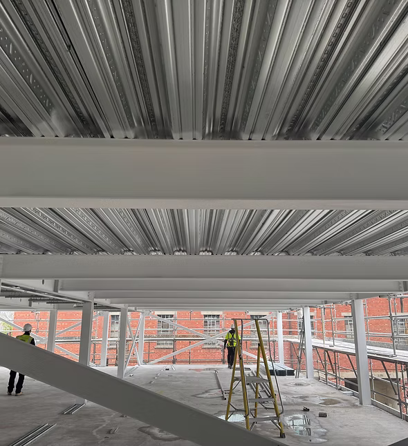 Intumescent coating being applied to structural steel beams on a construction site